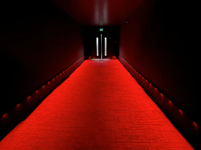 A glowing red carpet leading to a grand entrance decorated with twinkling fairy lights.
