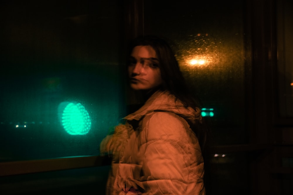 a woman standing in front of a green light