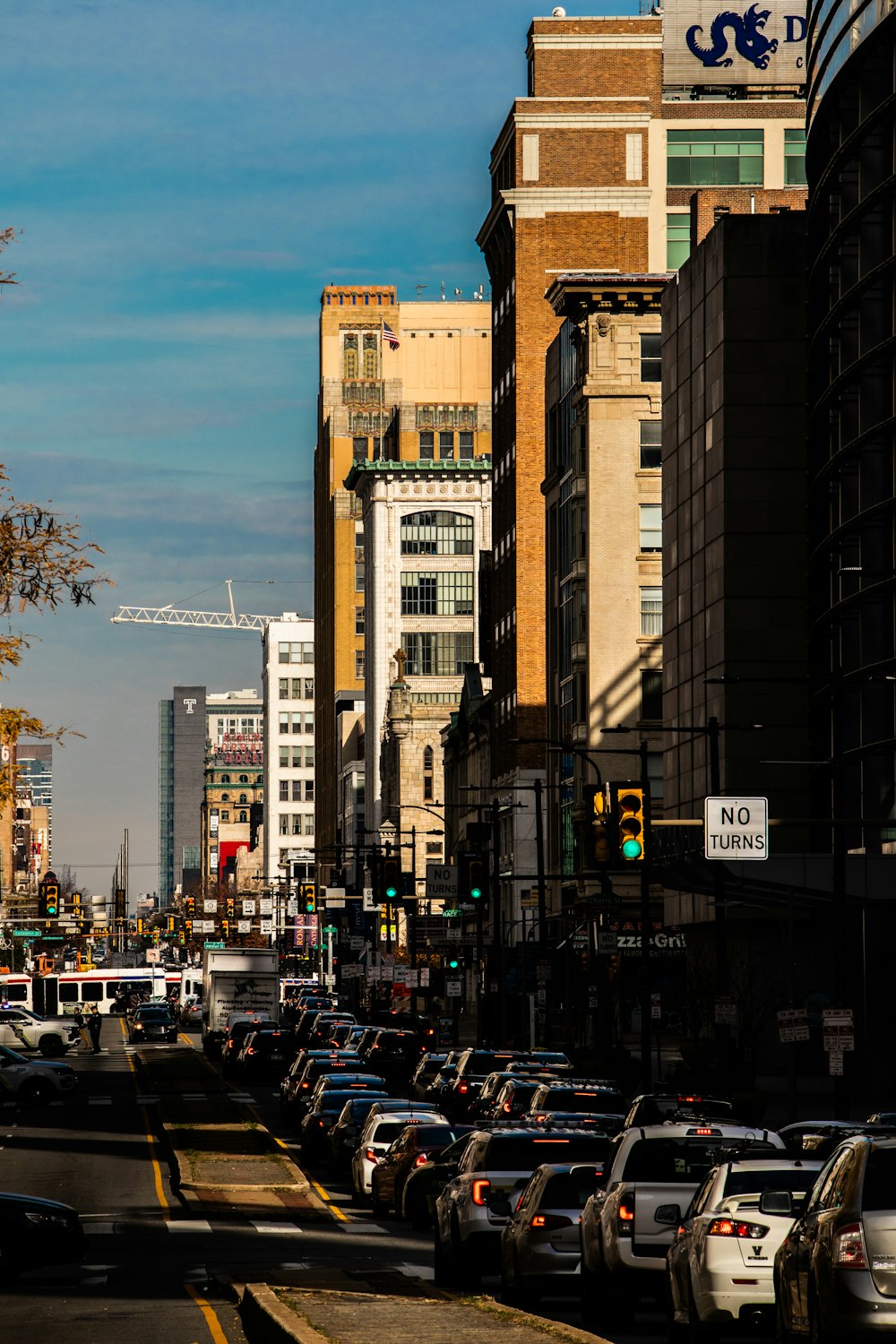 a city street filled with lots of traffic next to tall buildings