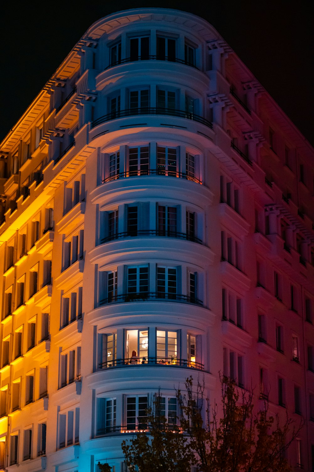 Un edificio alto con ventanas iluminadas por la noche