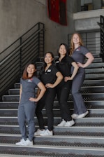 a group of women standing on top of a set of stairs