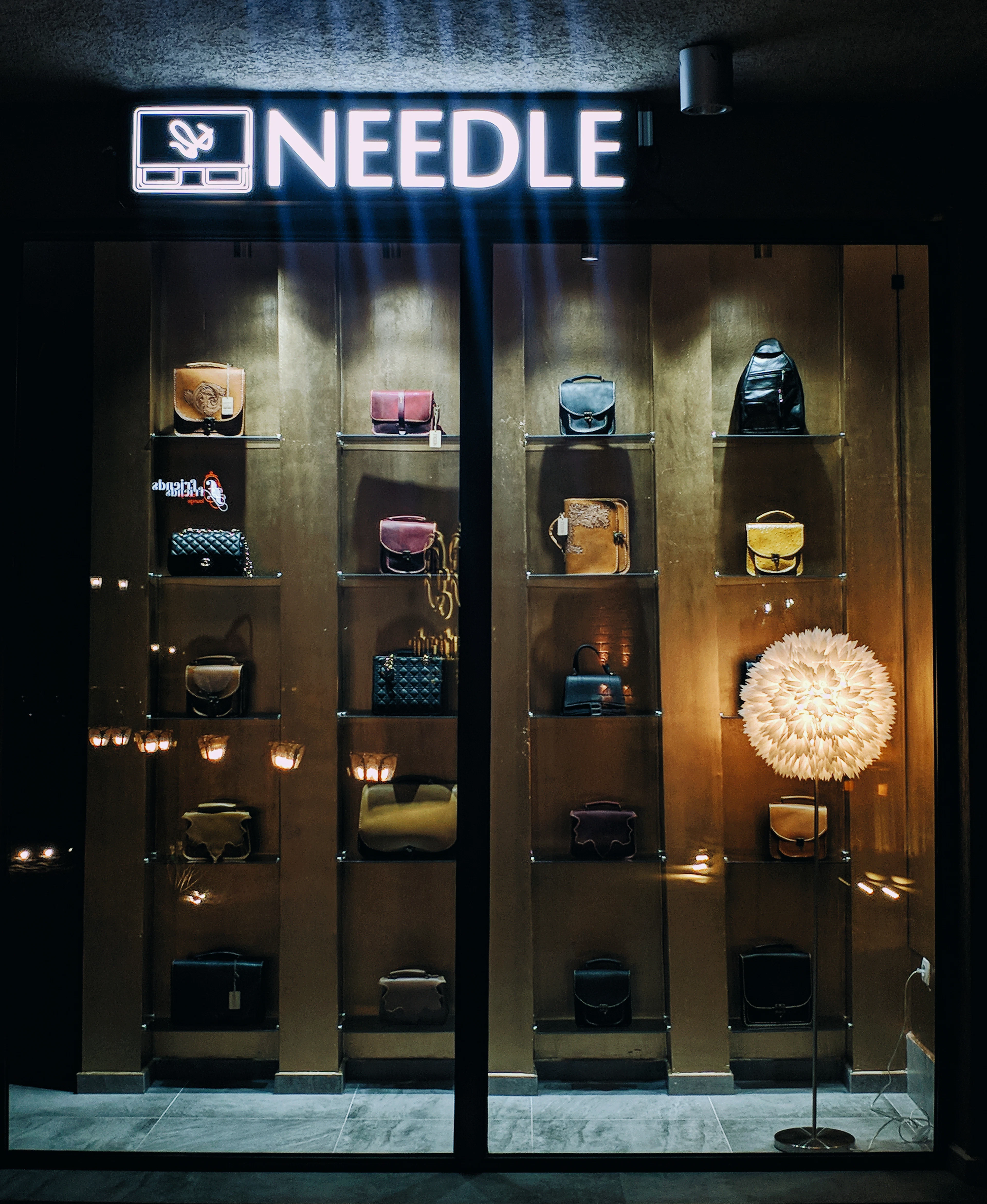Handbags displayed in lit dark cabinets