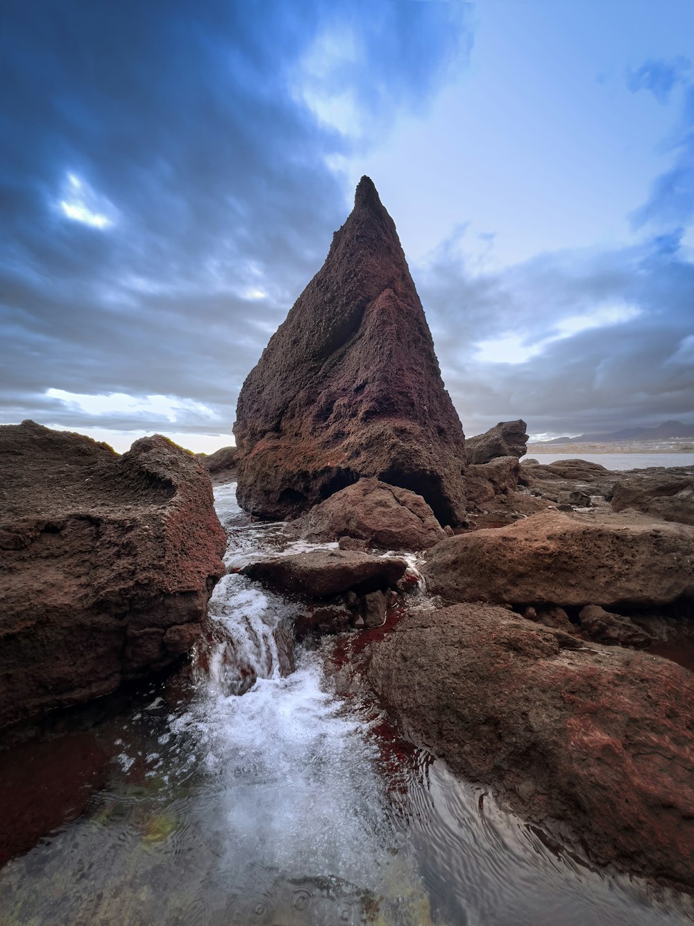 a rock formation in the middle of a body of water