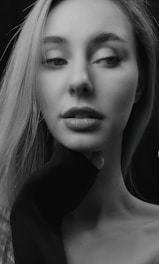 Black and white portrait of a thoughtful woman in a professional setting, reflecting depth and confidence.