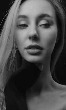 Black and white portrait of a thoughtful woman in a professional setting, reflecting depth and confidence.