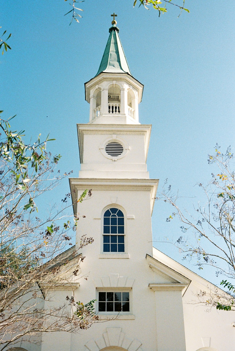 uma igreja branca com um campanário e um relógio