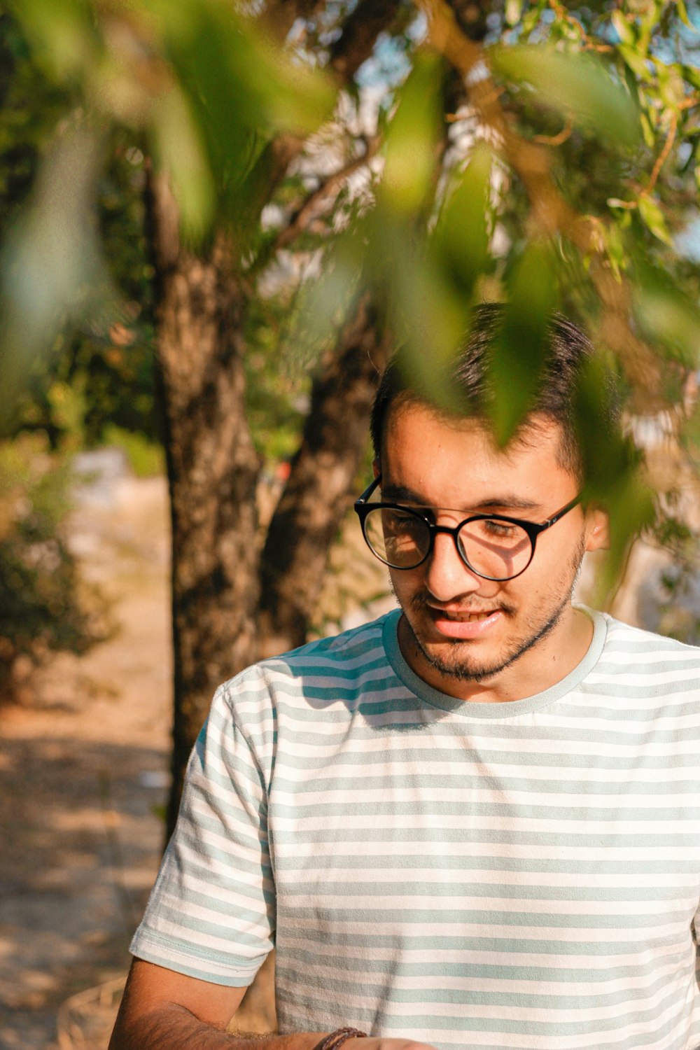 a man wearing glasses looking at his cell phone