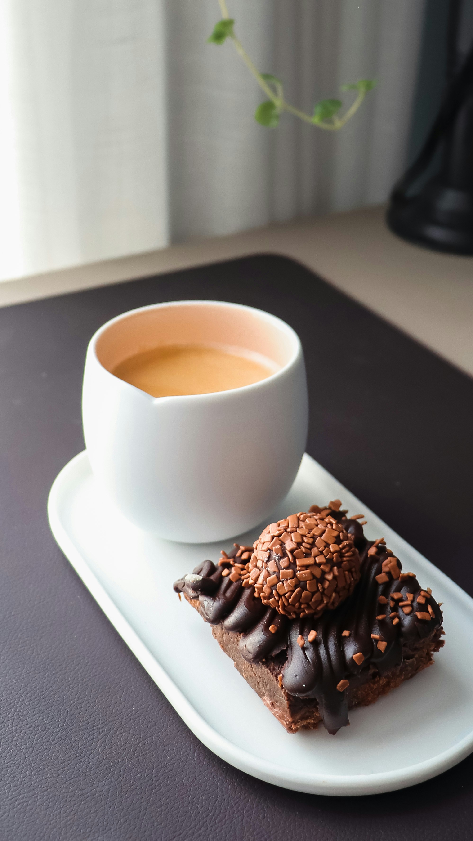 eine Tasse Kaffee und ein Stück Schokoladenkuchen auf einem Teller