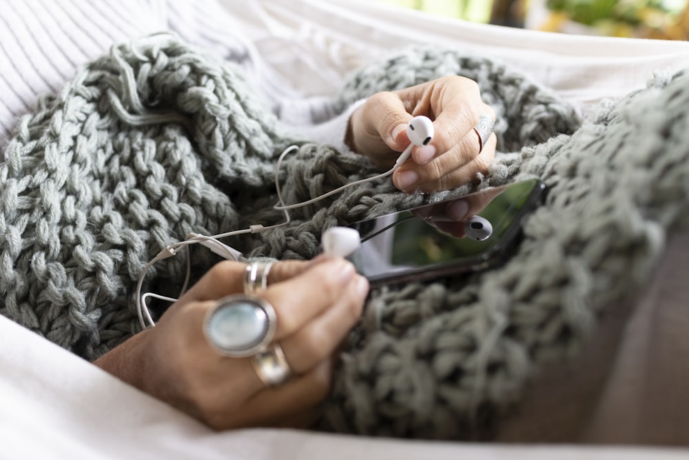 a woman laying in a hammock holding a cell phone