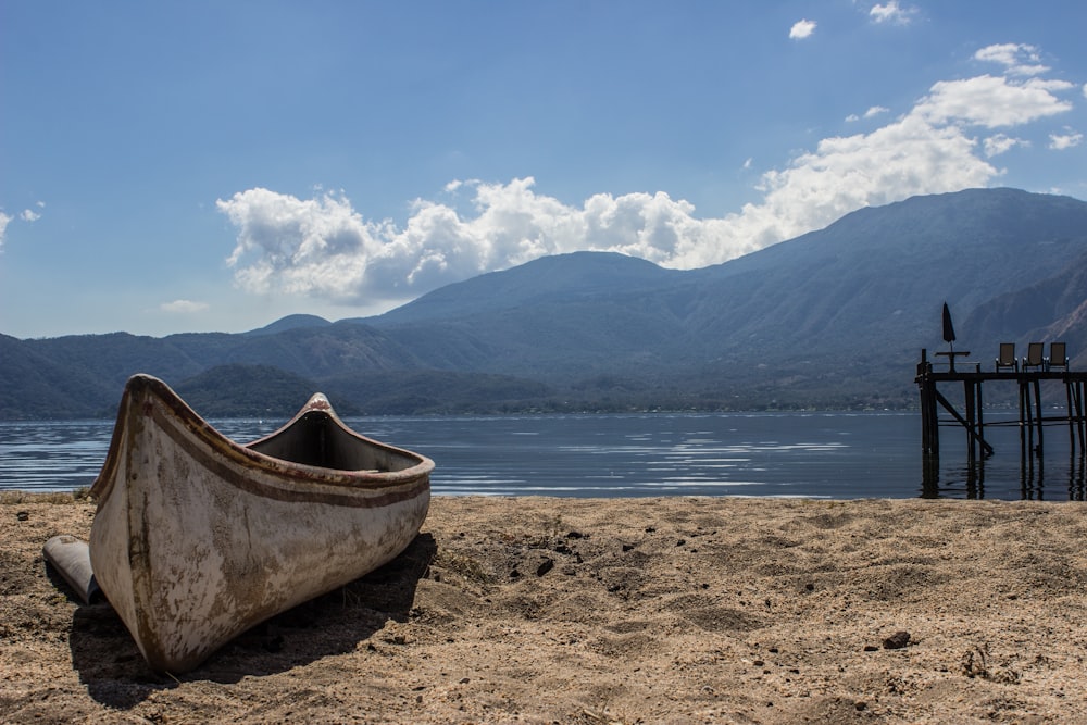 a boat sitting on top of a sandy beach