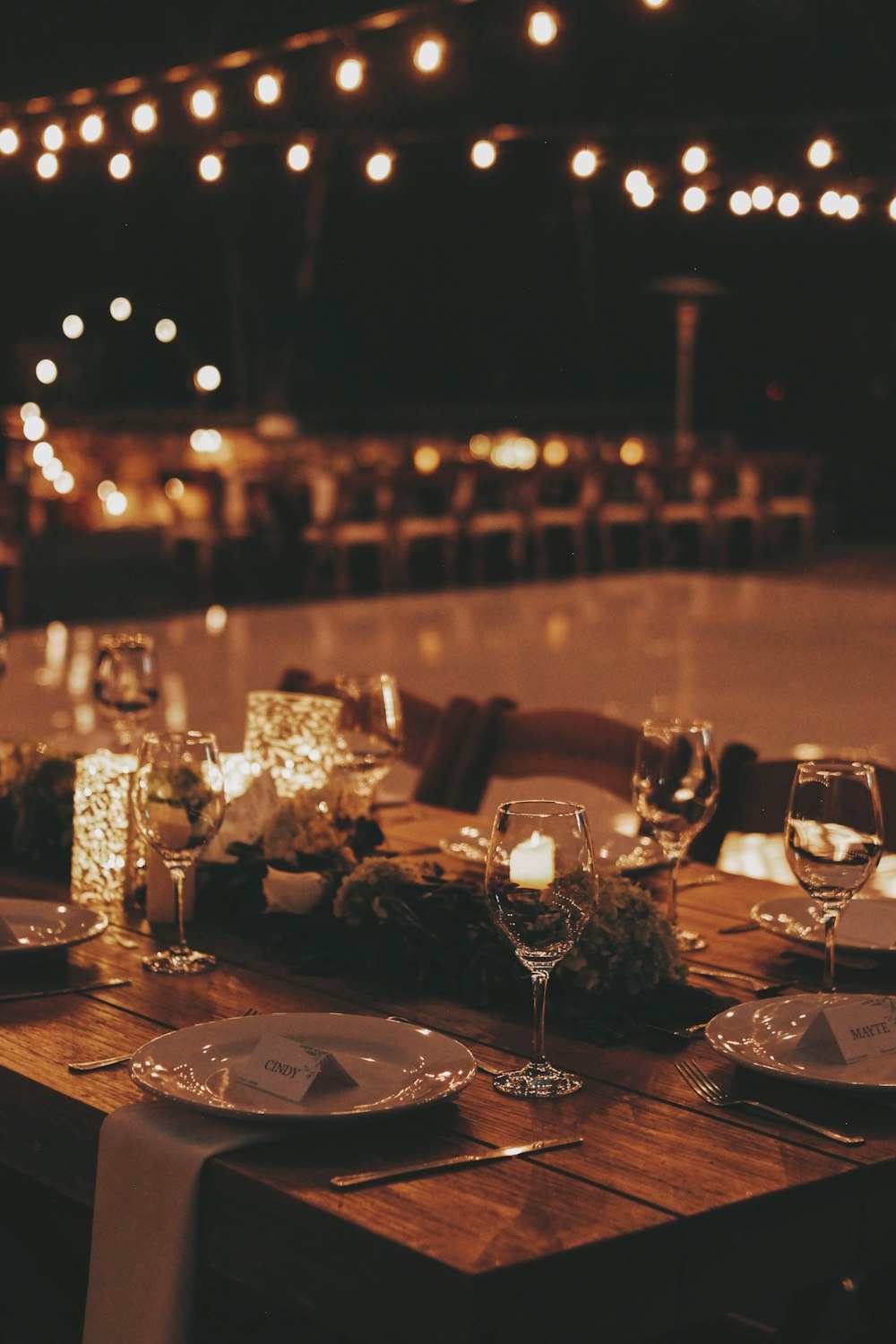 a wooden table topped with plates and glasses