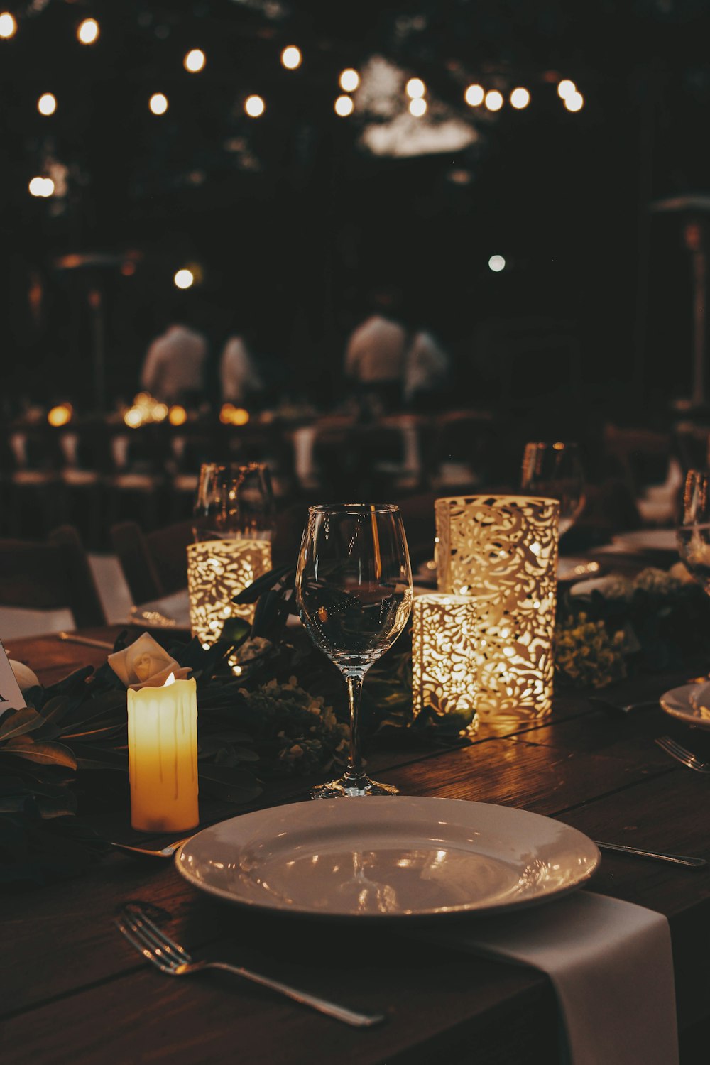 a dinner table with candles and place settings
