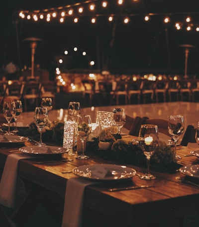 a table set for a formal dinner with candles and place settings