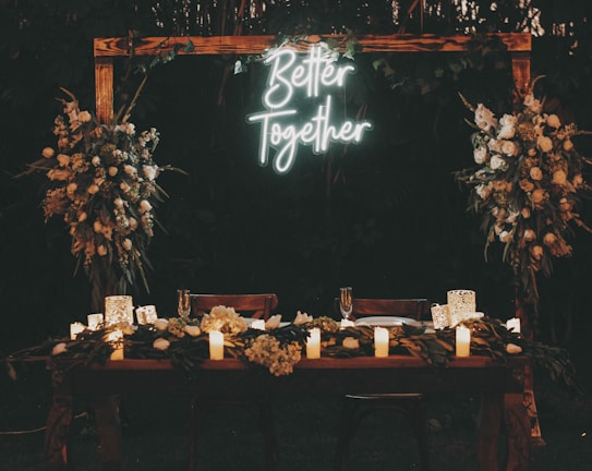 a wooden table topped with candles and flowers