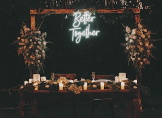 a wooden table topped with candles and flowers