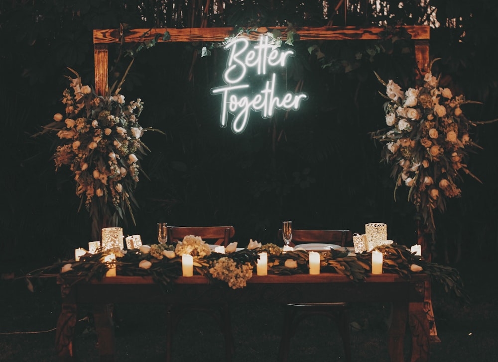 a wooden table topped with candles and flowers