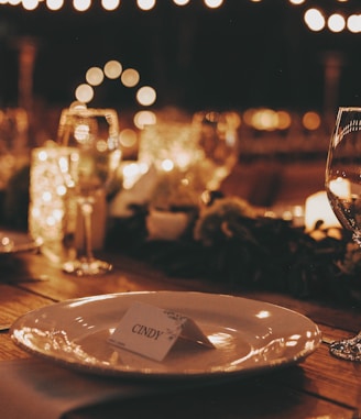 a table with a plate and wine glasses on it