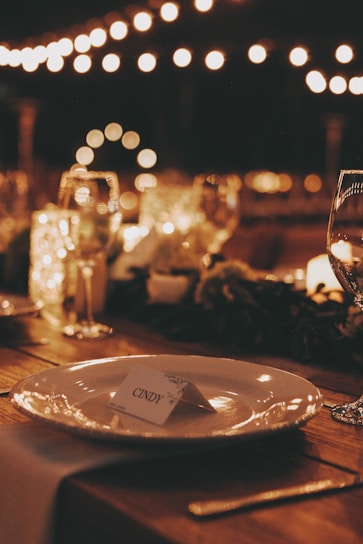 a table with a plate and wine glasses on it