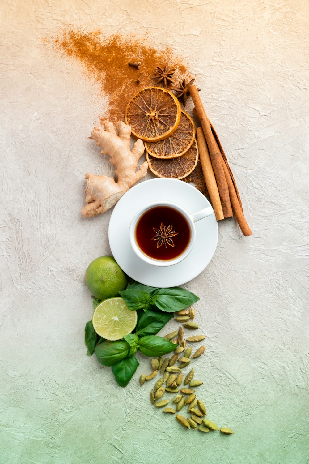 a cup of tea next to cinnamon, limes, limes and cinnamon sticks