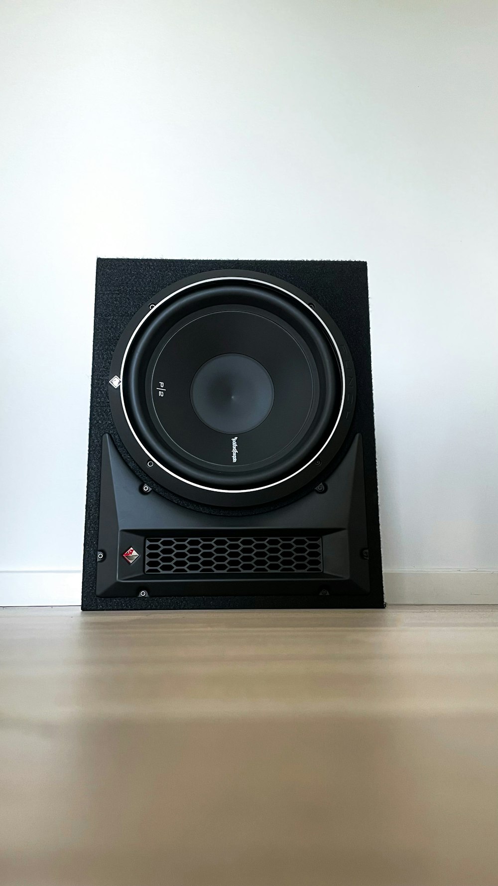 a subwoofer sitting on top of a hard wood floor