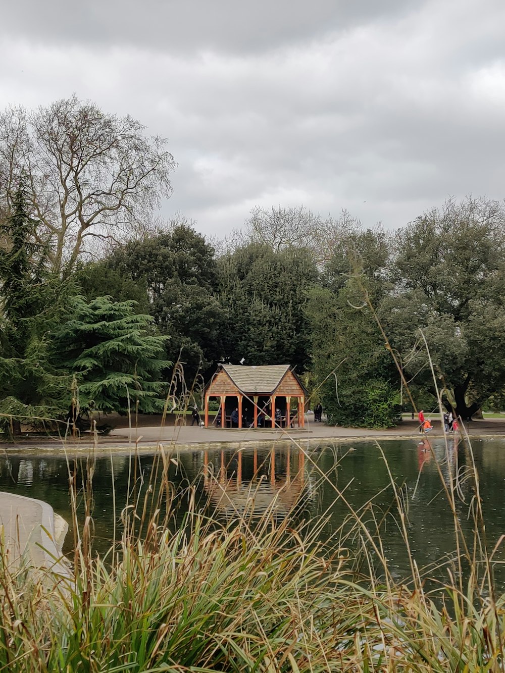 a lake surrounded by trees and a pavilion