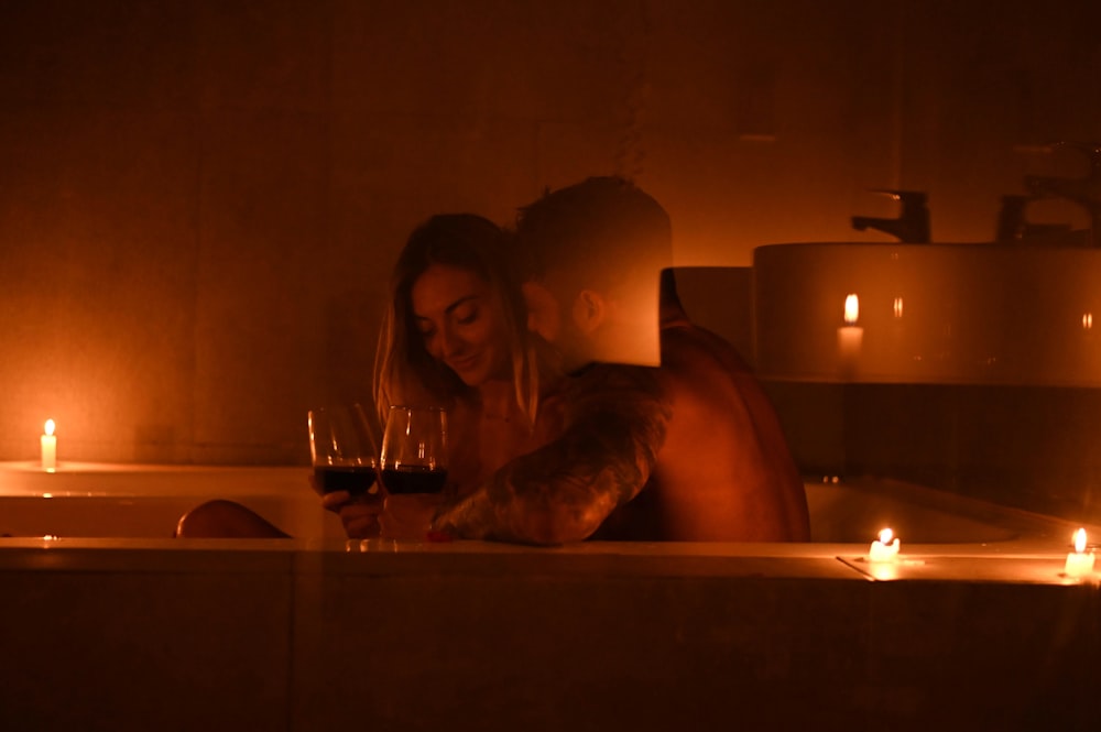 Una donna seduta in una vasca da bagno con un bicchiere di vino