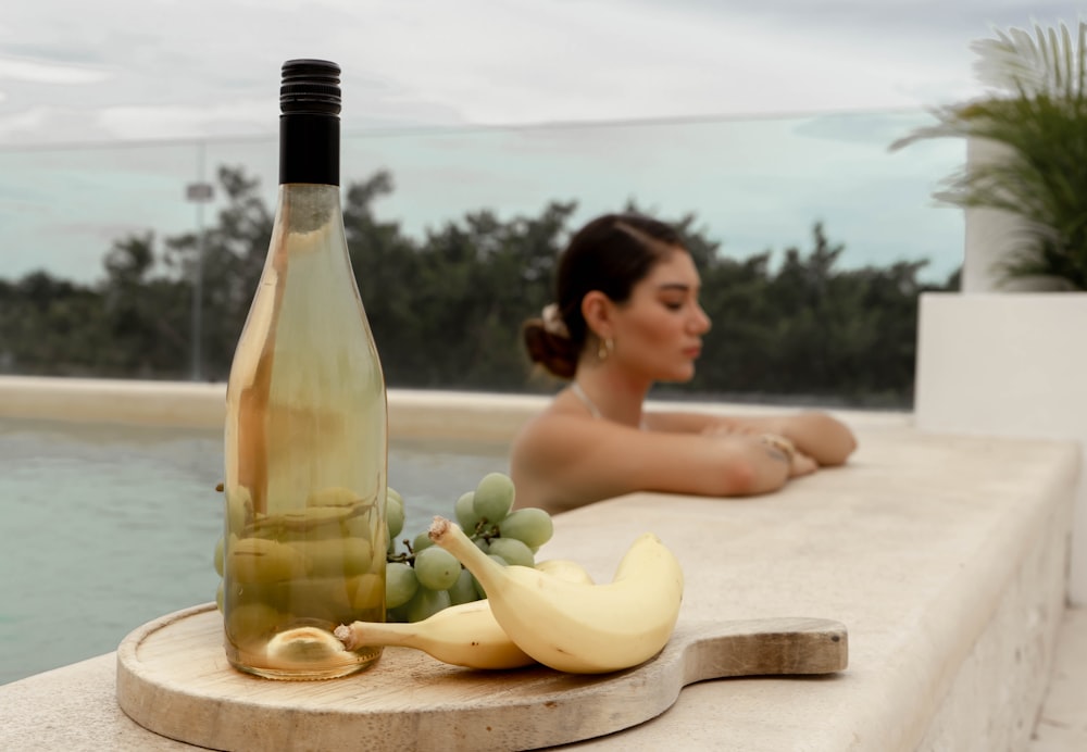 Eine Frau sitzt neben einer Flasche Wein