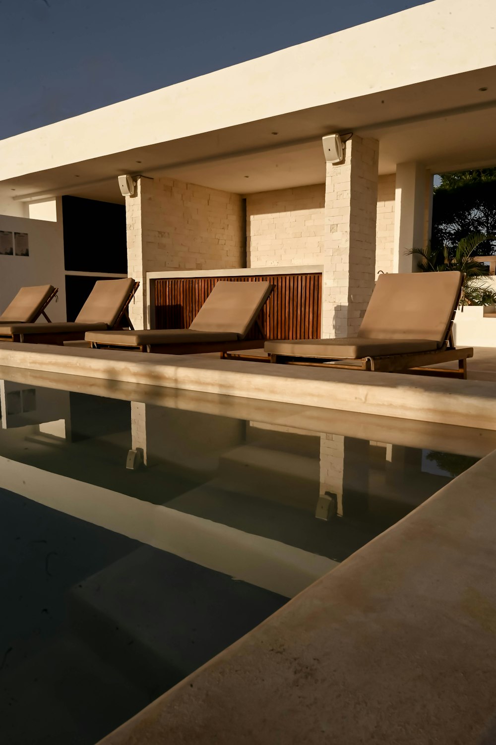 a row of lounge chairs sitting next to a swimming pool