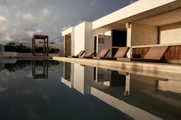 a long pool with lounge chairs next to it