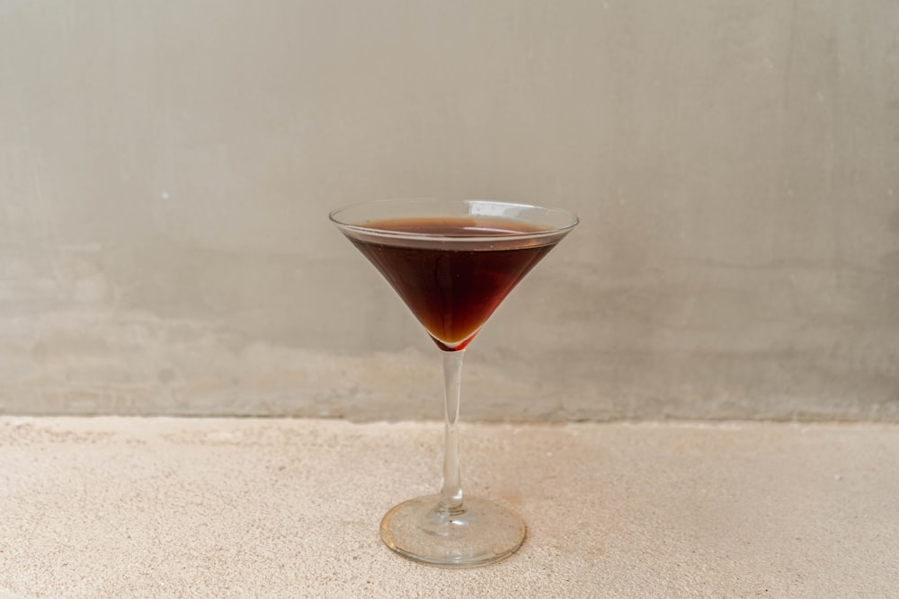 a glass filled with a liquid sitting on top of a counter