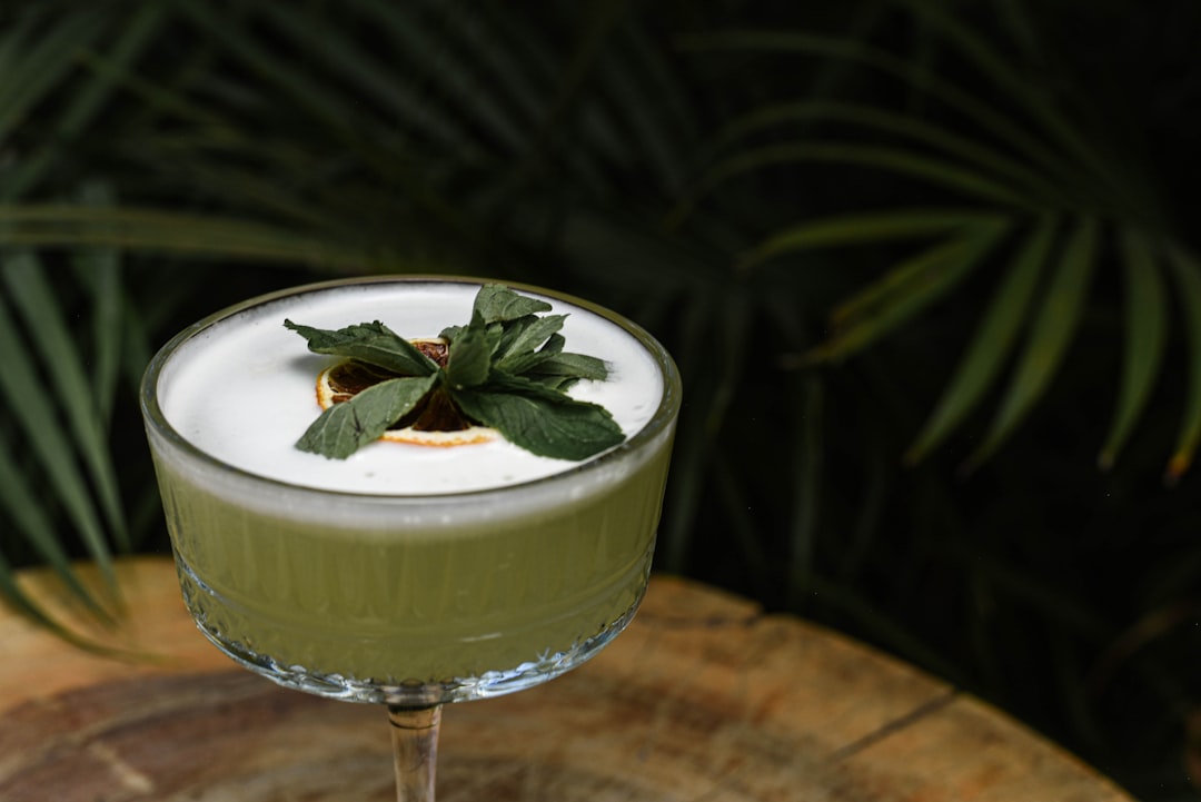 a green drink with a leaf on top of it,