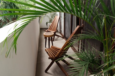 a couple of wooden chairs sitting on top of a balcony