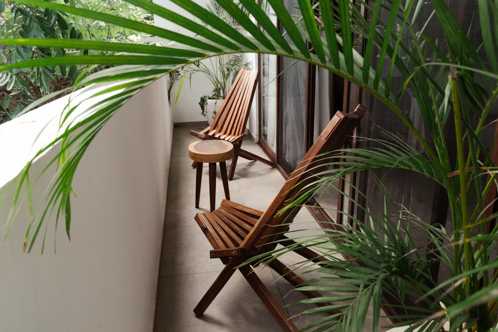 a couple of wooden chairs sitting on top of a balcony