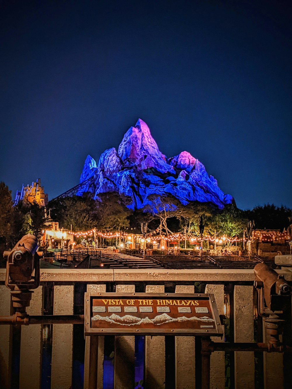 a night view of a mountain with a sign in front of it