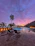 A serene view of the outdoor swimming pool at sunset with lounge chairs nearby.