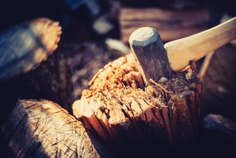 a close up of an axe stuck in a tree stump