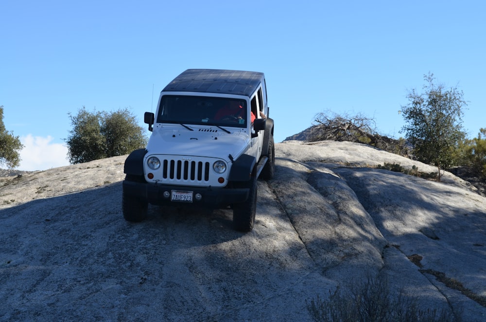 a jeep parked on top of a large rock