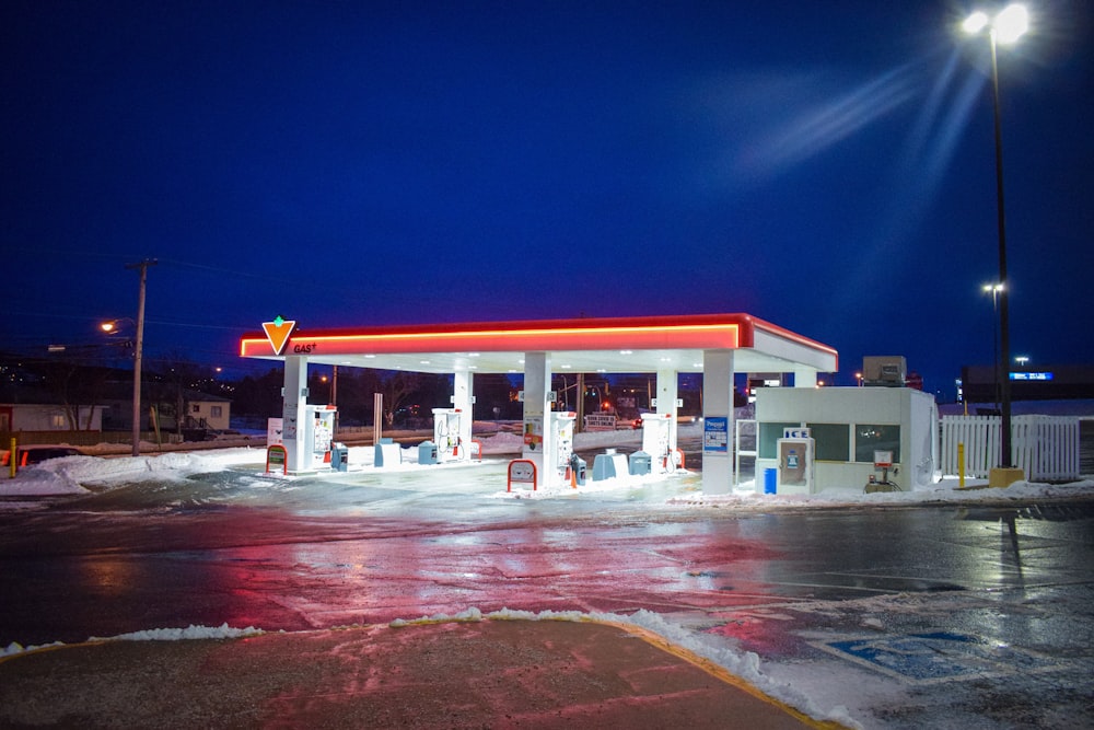Eine Tankstelle in der Nacht mit Schnee auf dem Boden