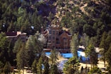 an aerial view of a mansion surrounded by trees