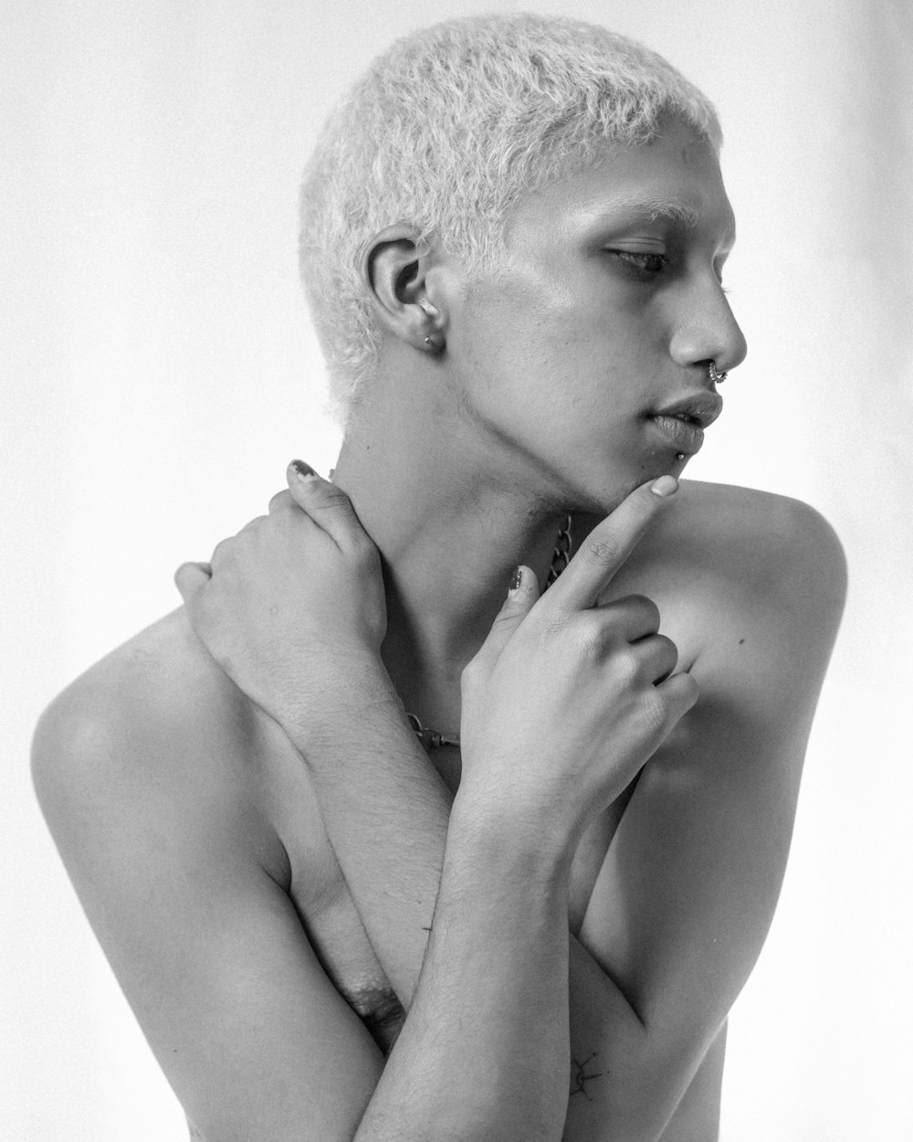 a woman with a shaved head and hands on her chest