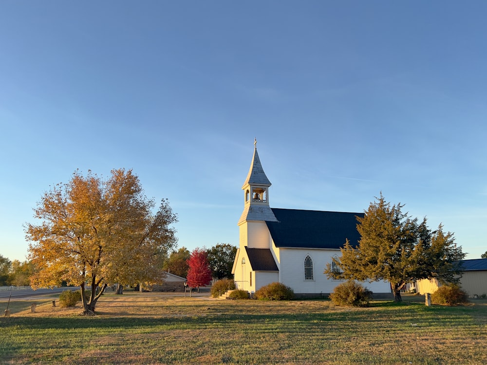 a white church with a black roof and a steeple