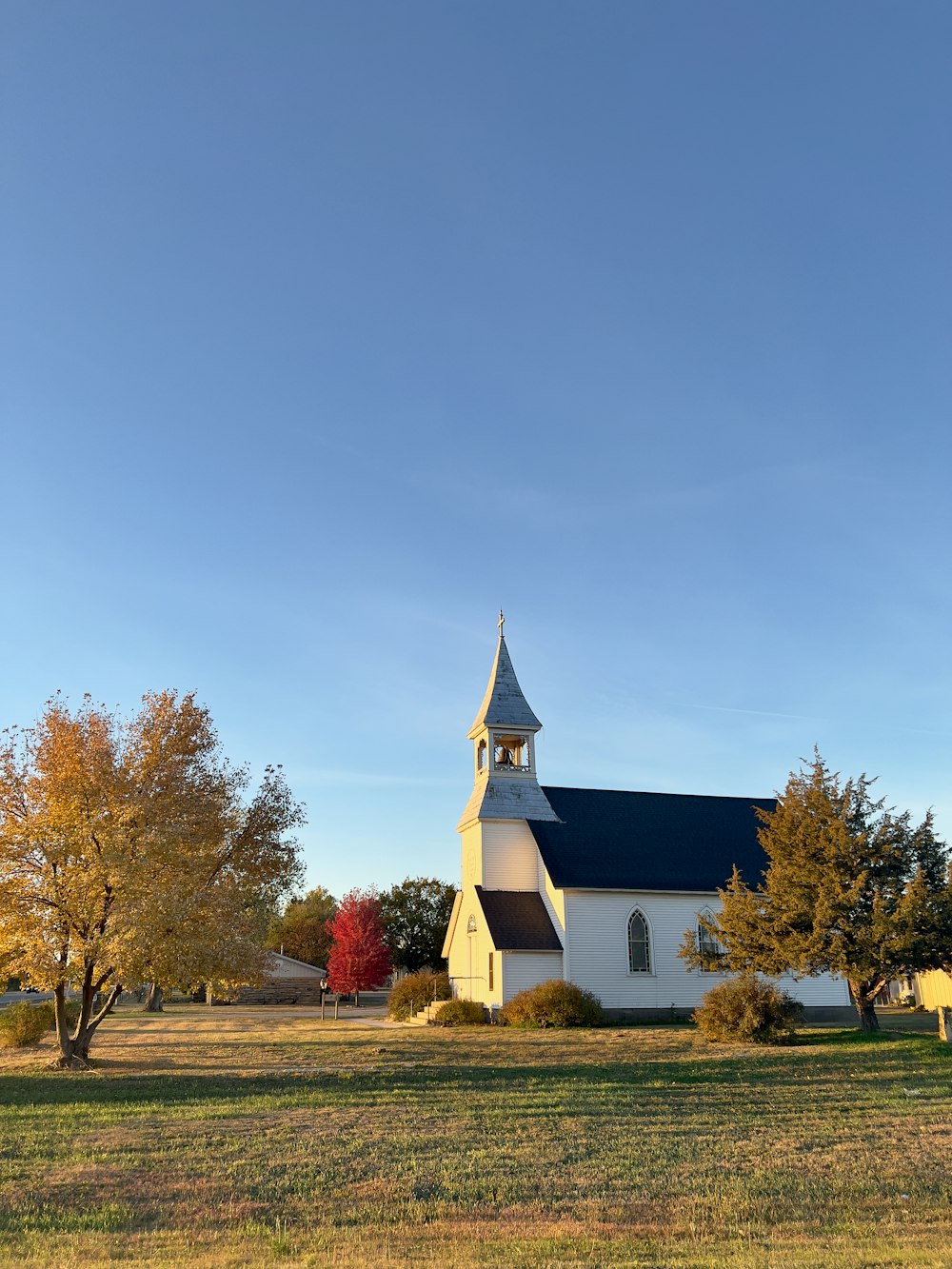 a white church with a black roof and steeple