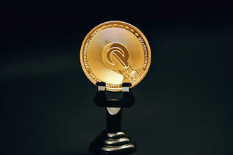 a gold coin sitting on top of a black stand