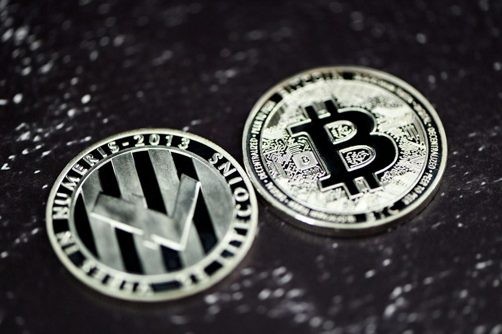 two bitcoins sitting side by side on a table