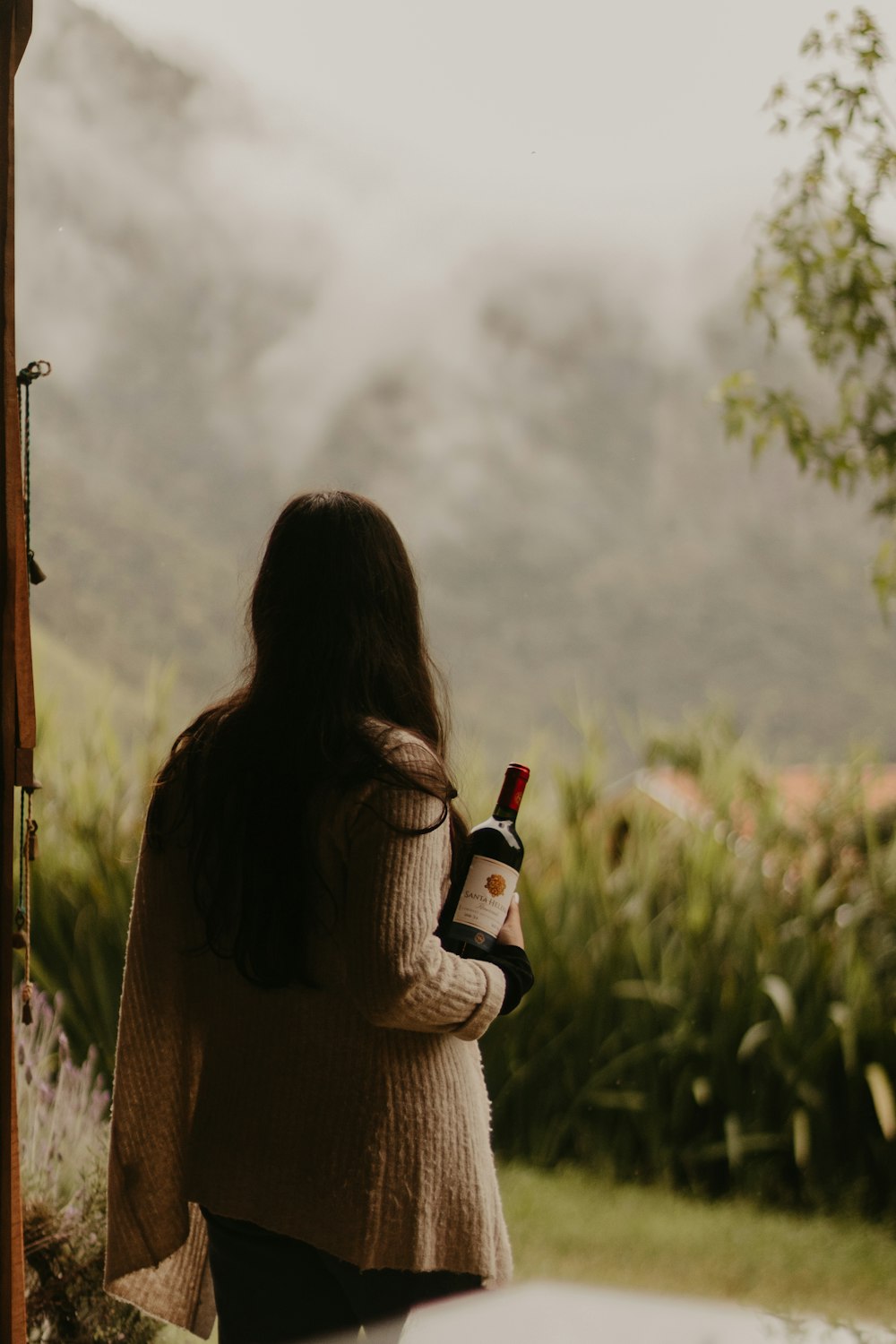 a woman holding a bottle of wine in her hand