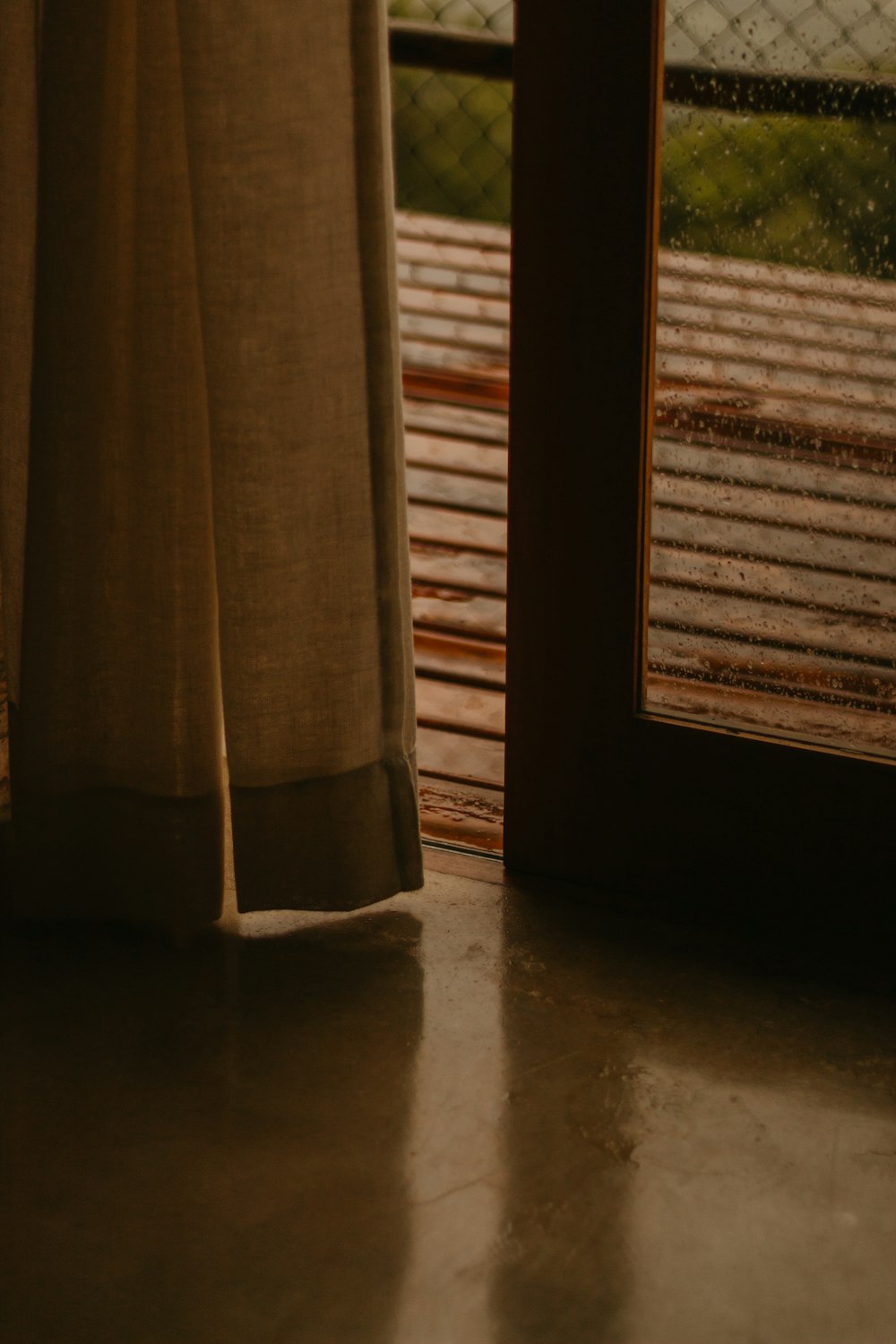 a window with a curtain and a wooden floor