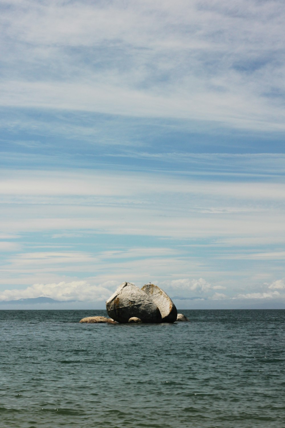 una gran roca en medio de un cuerpo de agua