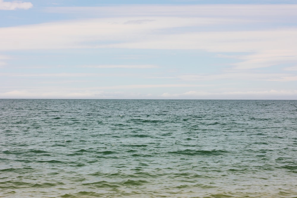 un grande specchio d'acqua seduto sotto un cielo blu nuvoloso