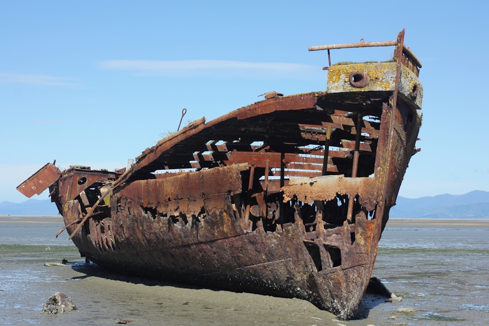 an old rusted boat sitting on top of a beach