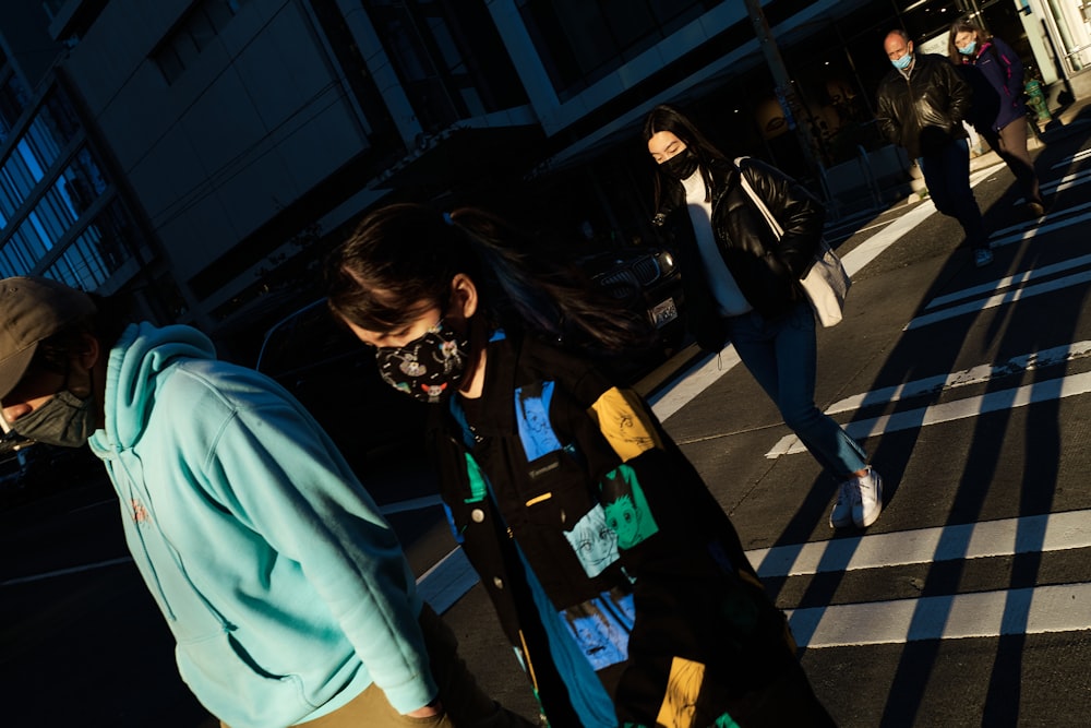 a woman wearing a face mask crossing a street